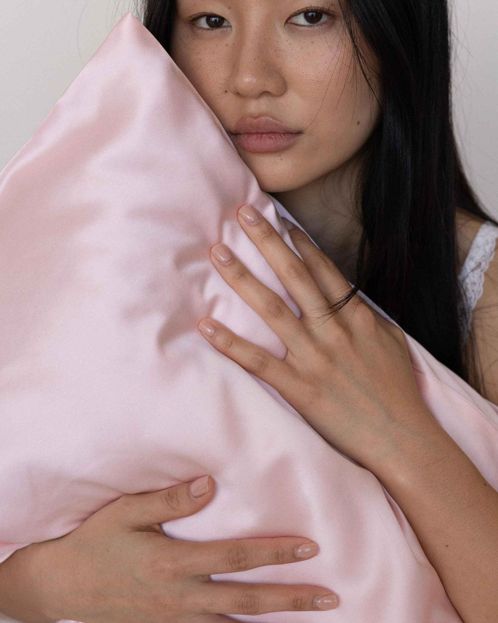 Holding the cased pillow close to the face