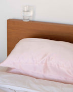 Blush | The Restore Case on a made bed with a timber headboard