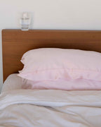 Blush | The Restore Case on a made bed, seen from the side