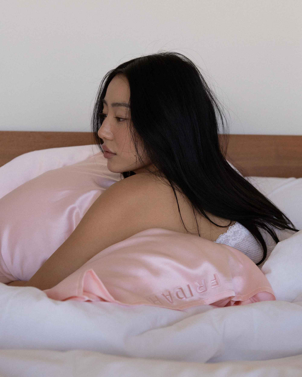 Sitting up in bed beside the cased pillow