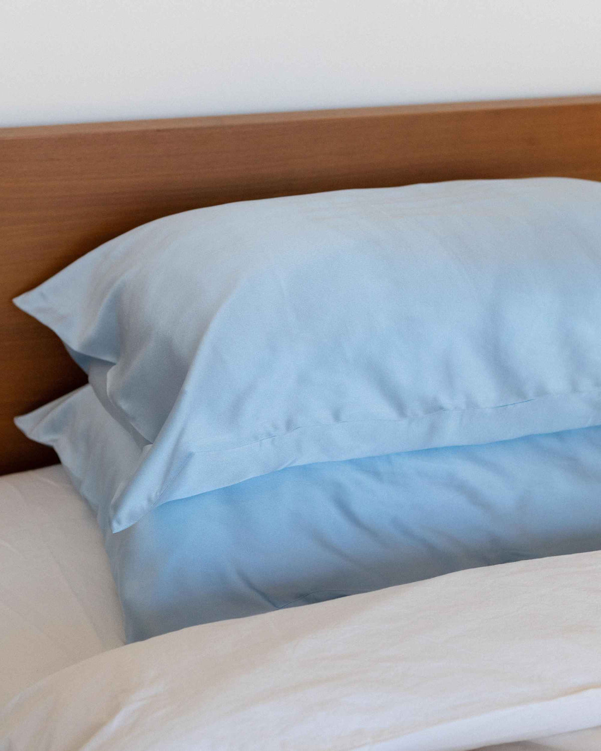 Stacked pillows in The Restore Case on a made bed
