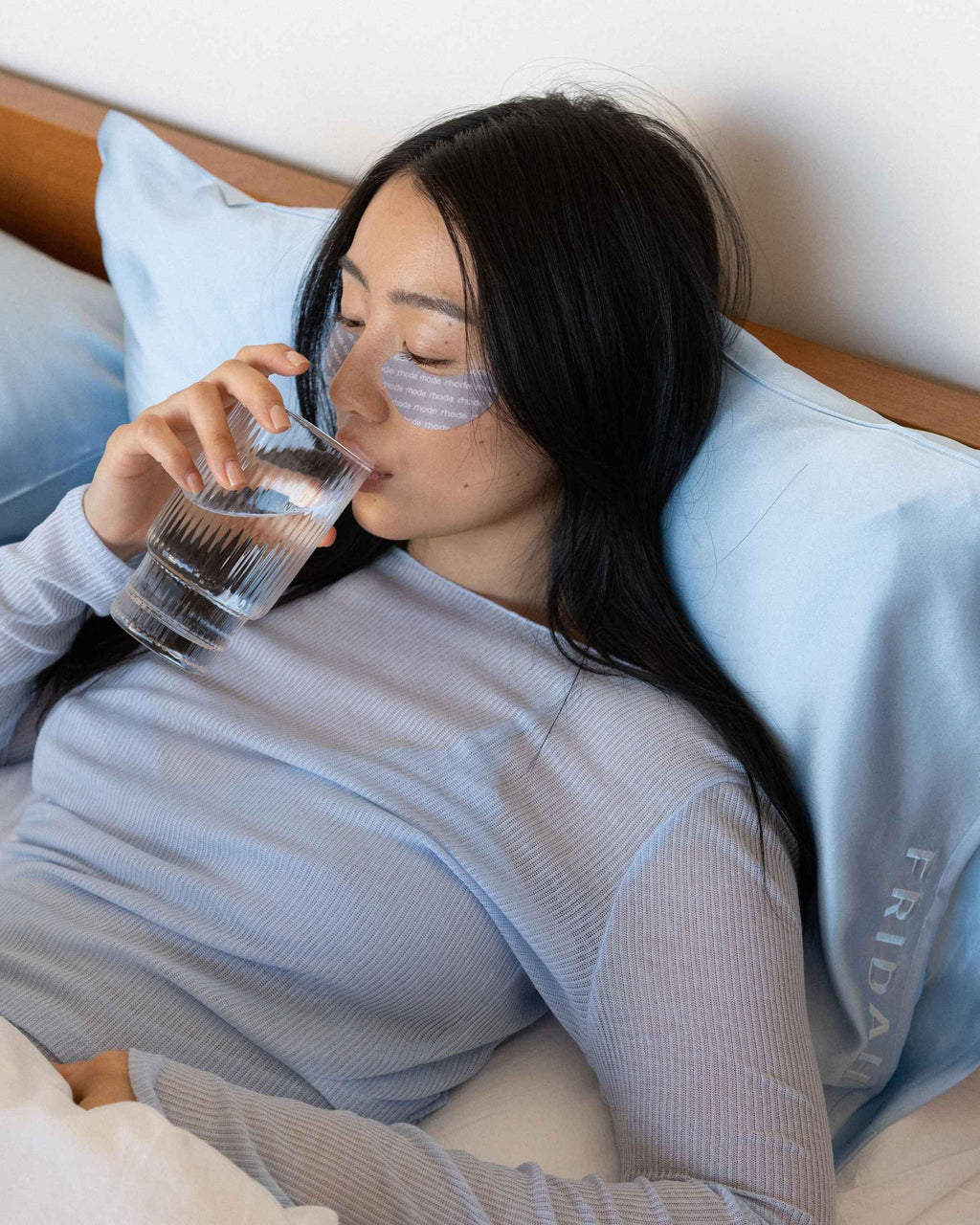 Drinking a glass of water in bed against the cased pillow